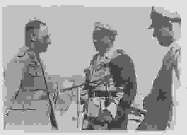 General Erwin Rommel steht im ägyptischen El Alamein zwei Generälen gegenüber
